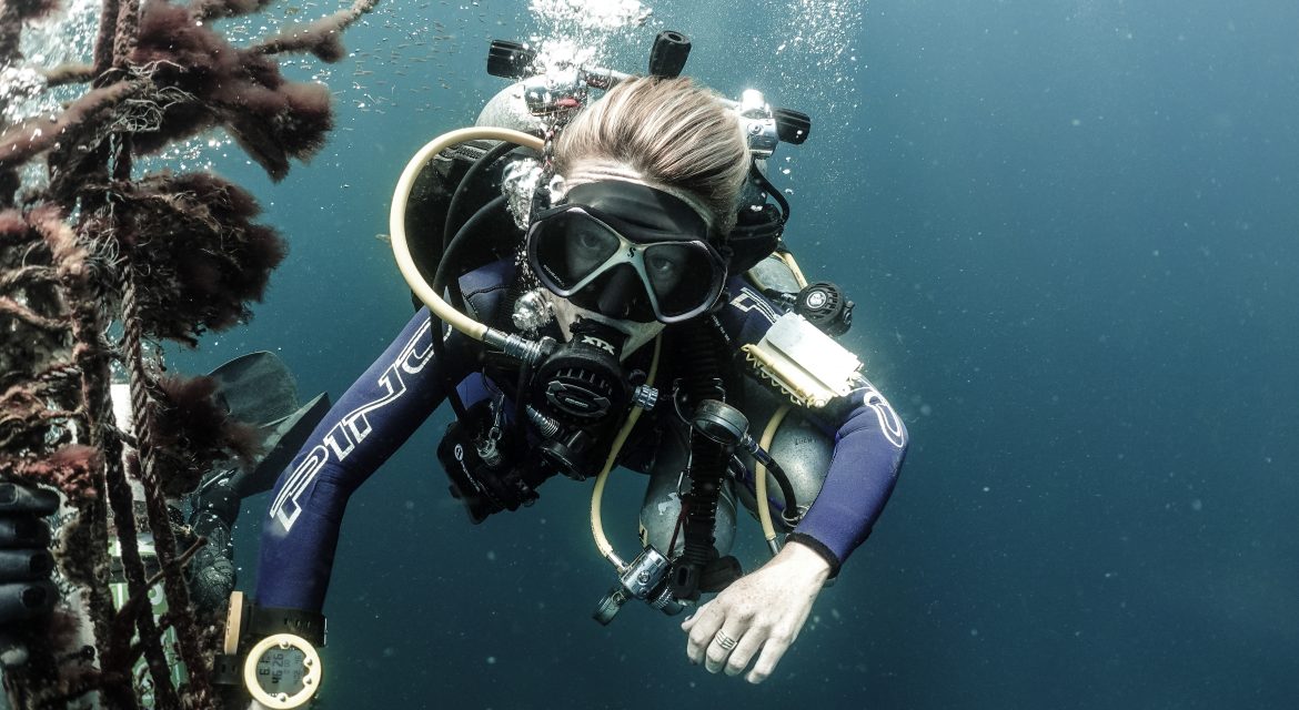 Female tech diver holding mooring line.